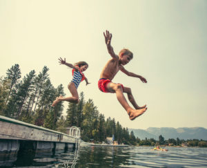Children jumping off of dock
