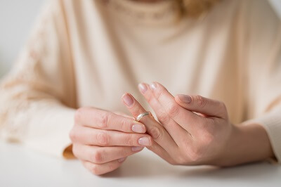 Closeup of woman's hands as she removes her wedding band